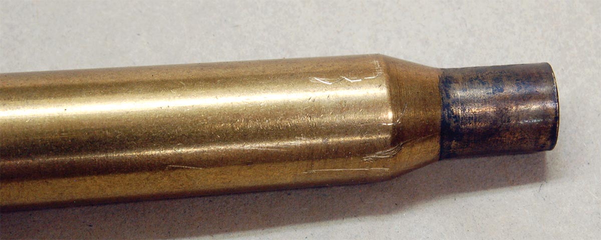 The scratches on this .270 Winchester case were caused by sharp edges when the case was forcefully pulled rearward. Using small files to remove sharp edges is helpful, but it will not eliminate the condition.